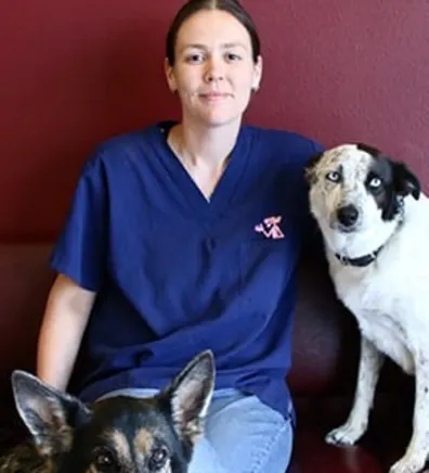 Jessica "JJ" smiling while holding two dogs